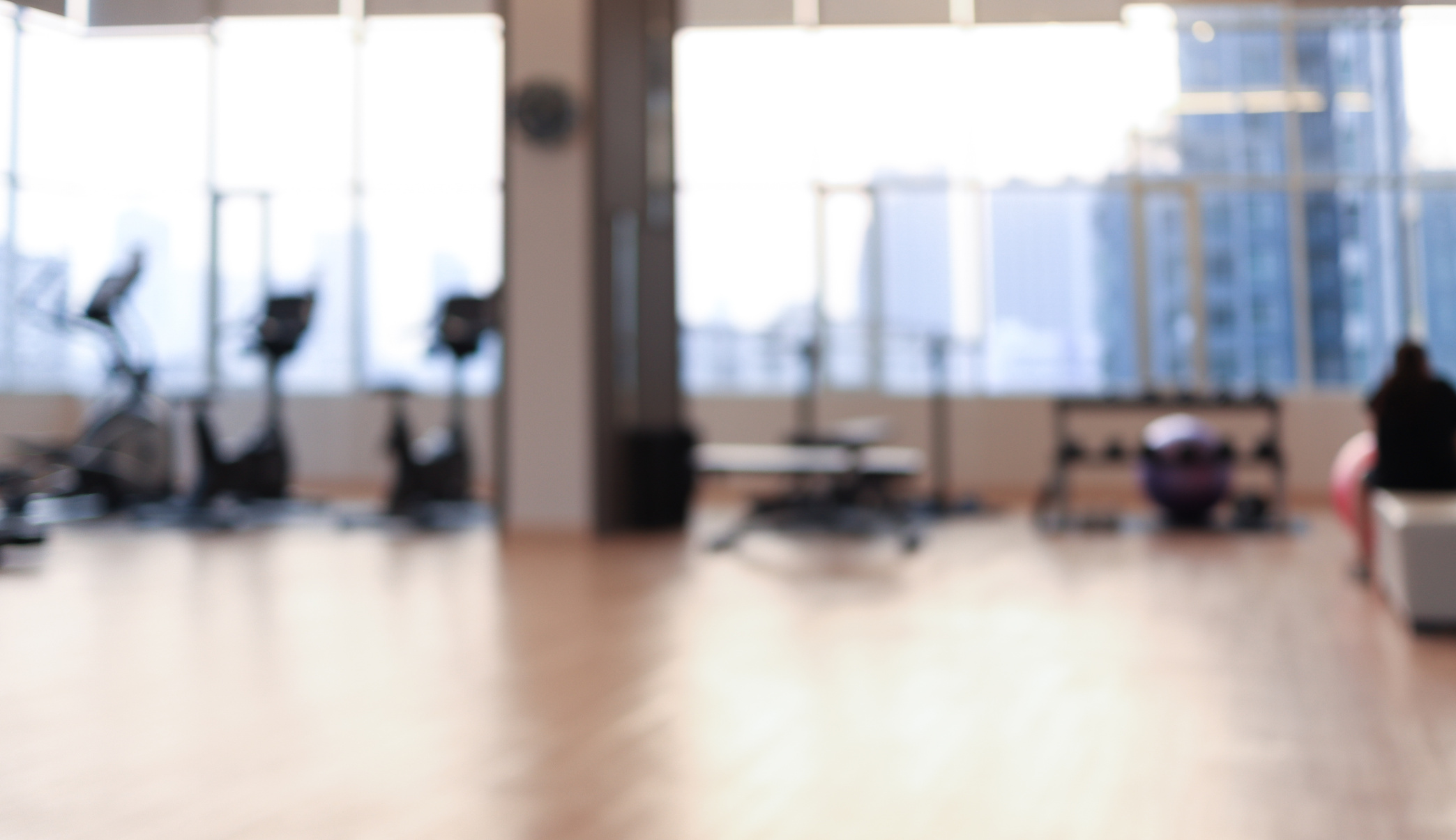 Blurred fitness room with Modern light gym. Sports equipment in gym.