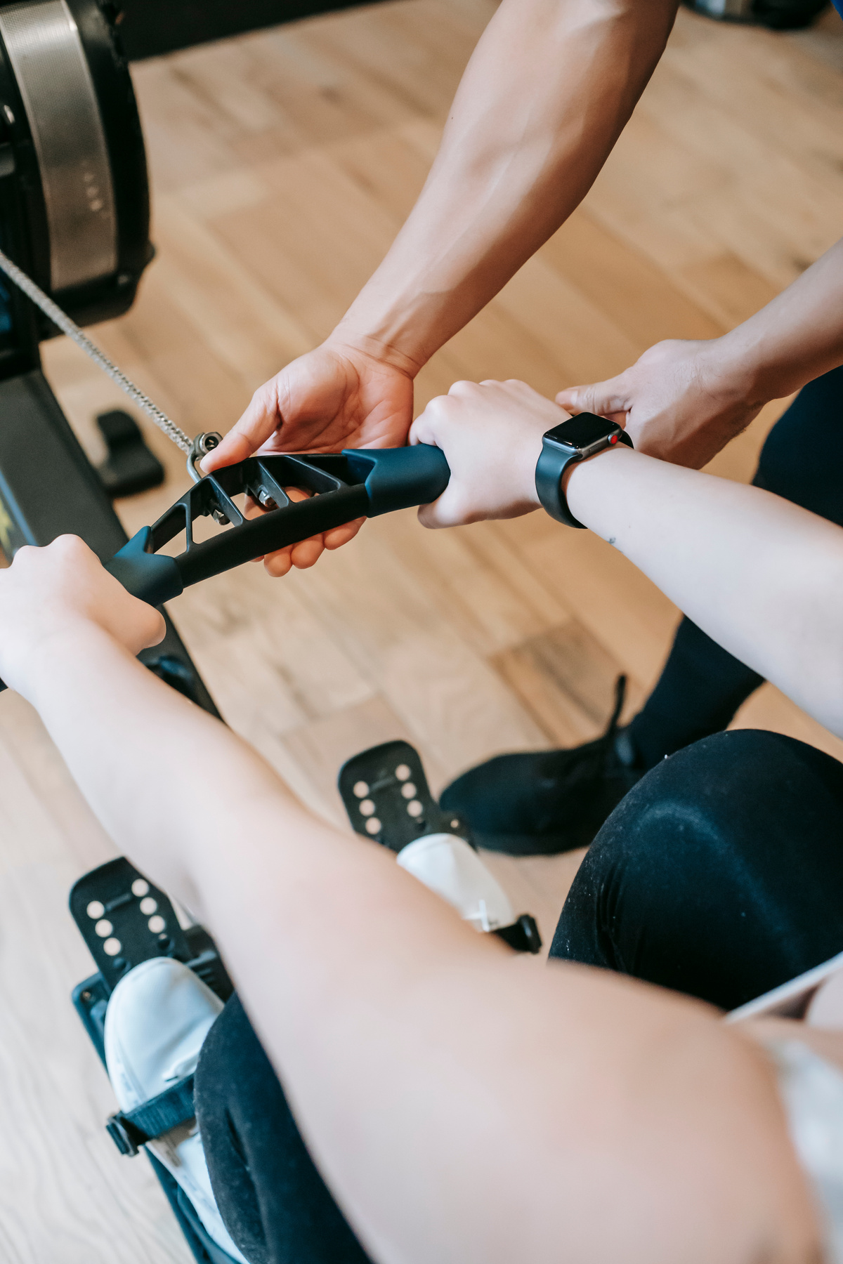 Woman training on machine with personal coach